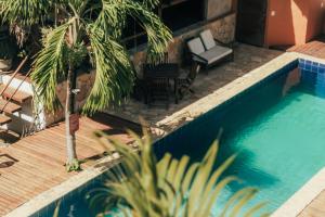 a resort with a pool and a chair and palm trees at Pipa Panorama Flats&Apartamentos in Pipa
