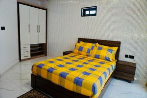 a bedroom with a bed with a yellow and blue blanket at Yande Homes in Mama