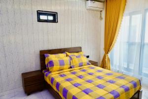 a bedroom with a bed with a yellow and blue comforter at Yande Homes in Mama