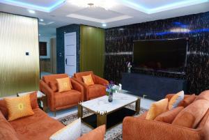 a living room with orange furniture and a flat screen tv at Yande Homes in Mama