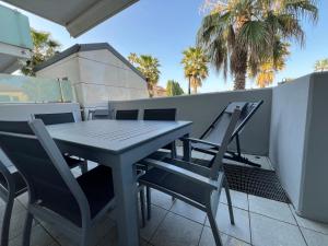 a table and chairs on a balcony with palm trees at Palm Grove House con terrazzo e box privato in Loano