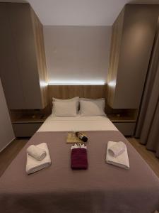 a bed with two towels and two shoes on it at Nido Estivo 1 in Nea Skioni