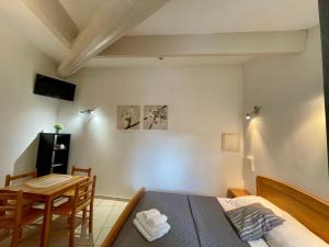a bedroom with a bed and a dining room table at Hotel L'Escale in Aigues-Mortes