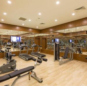 a gym with several treadmills and elliptical machines at Yilmazoglu Park Hotel in Gaziantep