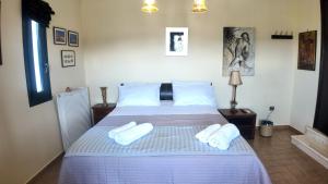 a bedroom with a bed with white slippers on it at Villa Arena Theologos in Theologos +21 photos