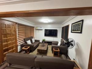 a living room with a couch and a table at Green Life Apartment in Sakumona