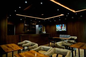 a restaurant with tables and chairs and a tv at Motion Hotel and Suites, Uyo in Uyo