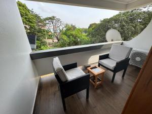 a room with two chairs and a table and a window at Green Life Apartment in Sakumona