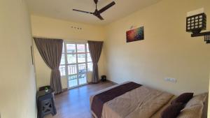 a bedroom with a bed and a ceiling fan at Grace place in Vagamon +11 photos