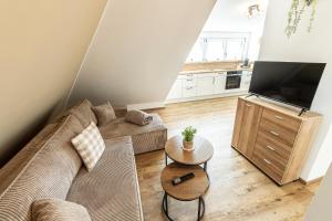 a living room with a couch and a tv at Ferienbahnhof Fichtental Bahnhofs-Loft in Prackenbach