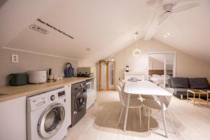 a kitchen and living room with a washer and dryer at GreeneStay Sindang DDP Seoul in Seoul