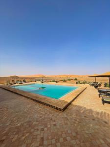 a swimming pool in the middle of the desert at Merzouga heritage camp in Merzouga