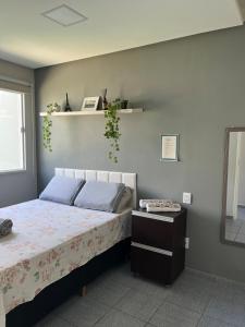 a bedroom with a bed with blue pillows at Casa aconchegante em Aracaju na Aruana in Aracaju