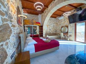 a bedroom with a bed in a stone wall at Villa Rokka Luxe - Free Private Heated Pool, Hot Tub, and more in Kissamos +95 photos