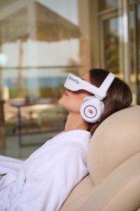 a woman laying on a couch wearing virtual reality headsets at TheLifeCo Sharm El Sheikh in Sharm El Sheikh +34 photos
