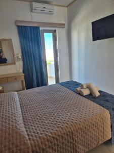 a bedroom with a bed with two towels on it at Christina Studios in Kefalos