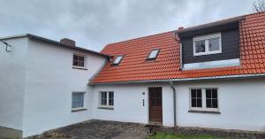 a white house with a red roof at Ferien- & Monteurwohnung Stößen in Stößen