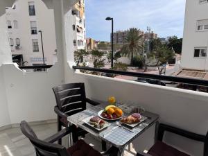 a table with a plate of fruit on a balcony at Spacious Apartment with 3 pools very central in Benalmádena