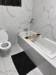 a white bathroom with a toilet and a bath tub at 3 on Eland in Vryheid