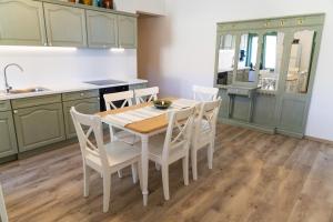 a kitchen with green cabinets and a table and chairs at Nostalgia in Turda