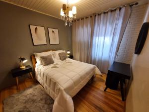 a bedroom with a bed and a chandelier at Hotel Vovó Carolina in Gramado
