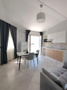 a kitchen and living room with a table and a couch at OndaMaris Tropea in Tropea