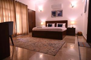 a bedroom with a bed with two lamps and a rug at Elevé Stays - Boutique Family Suites in Karachi