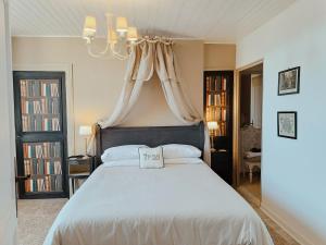 a bedroom with a large white bed with a chandelier at Maison Nº 20 in Eymet +31 photos