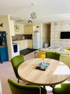 a kitchen and living room with a wooden table and chairs at The Coach House in Par