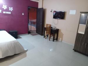 a bedroom with a bed and a tv on a wall at Safa residency hotel in Perintalmanna