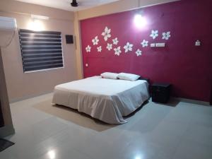 a bedroom with a bed with white flowers on the wall at Safa residency hotel in Perintalmanna