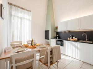 a kitchen with a table and chairs and a kitchen with white cabinets at Andromeda in Modugno