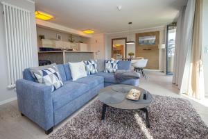 a living room with a blue couch and a table at Strandresort Prora - Wohnung 213 in Binz +17 photos