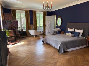 a bedroom with a bed and a bath tub and a tub at Le Château d'Elbeuf-en-Bray in Elbeuf-en-Bray