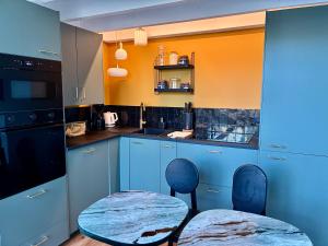 a kitchen with blue cabinets and a table with chairs at Blue dream in Carantec