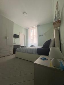 a bedroom with a bed and a table with a lamp at b&b La Rosa dei venti in Alassio
