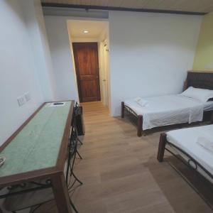 a room with two beds and a table in it at Sunflower Residences Capitol in Cebu City