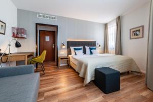 a bedroom with a bed and a desk and a chair at Hotel am Torturm in Volkach