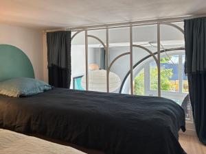 a bedroom with a bed and a large window at Blue dream in Carantec