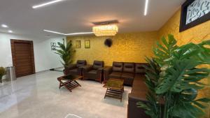 a waiting room with a couch and chairs in it at Waves Residency in Chennai