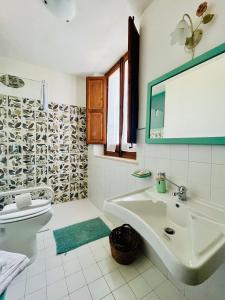 a bathroom with a sink and a toilet and a mirror at Baglio Fontanasalsa Agriturismo in Paceco +40 photos