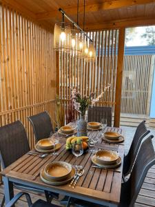 a wooden table with plates and wine glasses on it at Mobile Home Sea Heaven in Biograd na Moru +29 photos