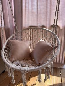 a swing chair with two pillows in a room at Mobile Home Sea Heaven in Biograd na Moru