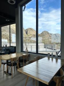a room with tables and chairs and a large window at Torghatten Lodge in Torget