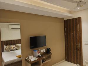 a hotel room with a bed and a flat screen tv at Eennra Kaansabbati in Medinīpur