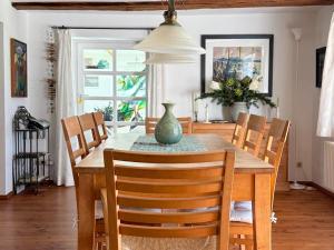 a dining room table with chairs and a vase on it at Landhaus Rubitz in Rubitz