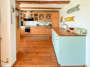 a kitchen with wooden cabinets and a wooden floor at Landhaus Rubitz in Rubitz