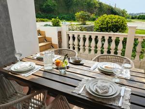 a wooden table with plates and glasses on a patio at Casa Corral Bouzamayor in Valdoviño