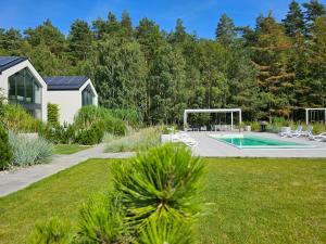 a yard with a swimming pool and a house at NOVA ULINIA Sand - dom nad morzem, podgrzewany basen,sauna, balia z jacuzzi , Starlink in Ulinia