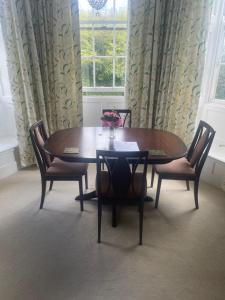 a dining room table and chairs in a room with a window at Brightling Park in Brightling +5 photos
